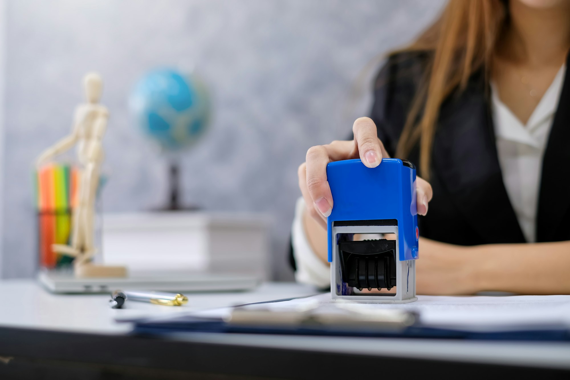 Close-up of a woman hand holding stamping a document at the office.